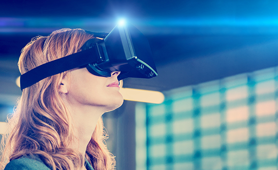 A light skinned woman with wavy hair wearing a virtual reality headset