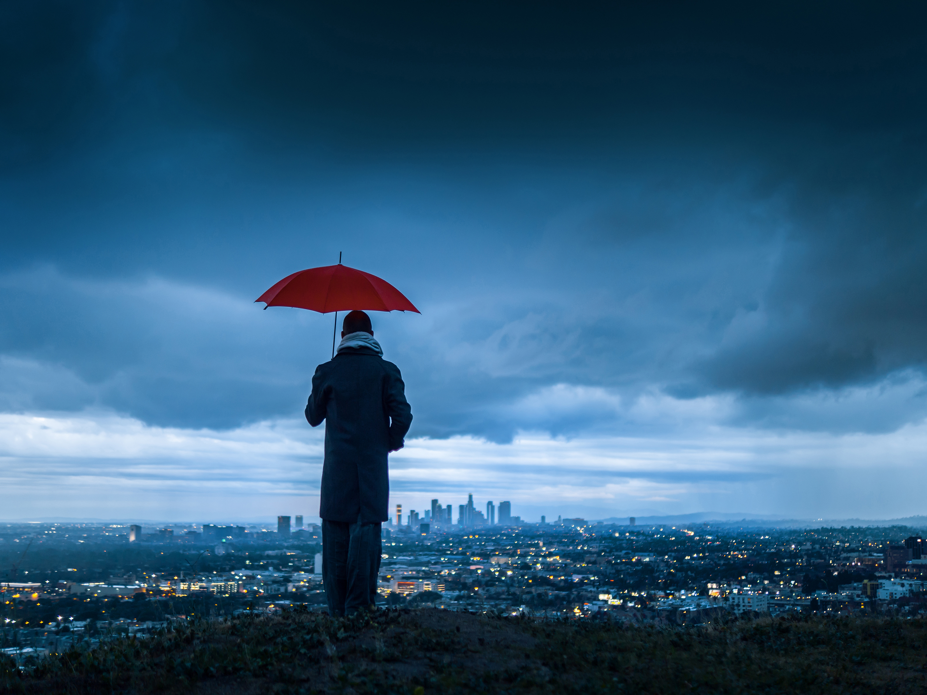 Image on the cover of the report featuring a man holding a red umbrella at the top of a hill and looking down at a city at dusk. Image on the cover of the report featuring a man holding a red umbrella at the top of a hill and looking down at a city at dusk.